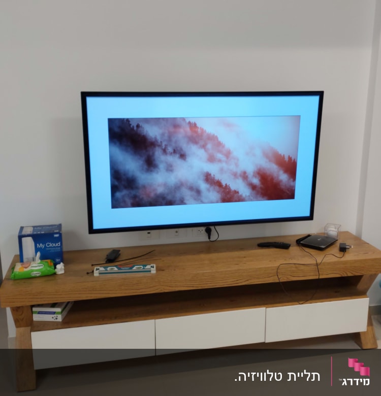 טלוויזיה על שולחן עץ עם שלט ומטען